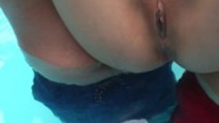 スキニー尻アジアの女は、プールで楽しんでいます